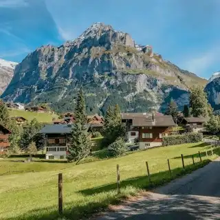 A scenic view of a mountain range with houses in the foreground — Bernese Oberland, Switzerland